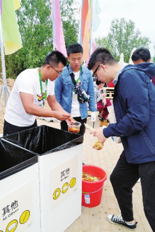  音乐节现场，志愿者引导乐迷进行垃圾分类。中国经济导报记者白雪/摄