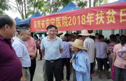 图为海南省卫生健康委员会副主任王锋(中)与村民交流。