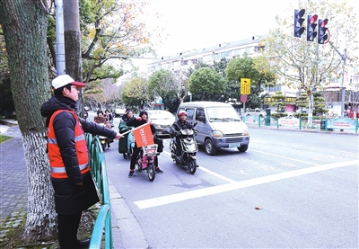 总能看到不少"红色的身影",他们协助交警疏导交通,引导市民文明出行