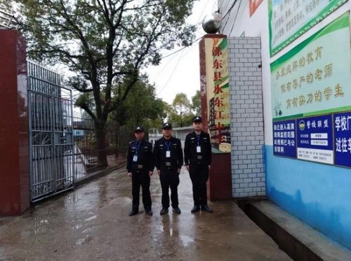 图为民辅警在校园门口站岗。