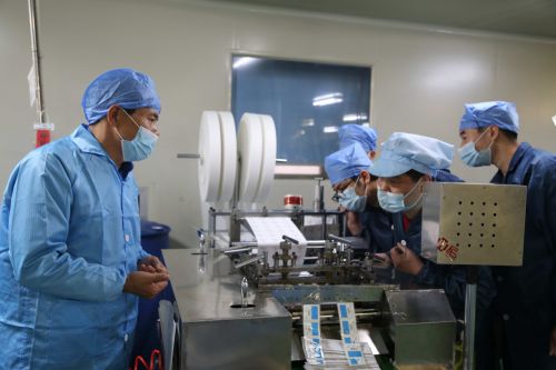 景迪医疗董事长陆建国（左一）在生产一线组织生产。记者沈贞海 摄