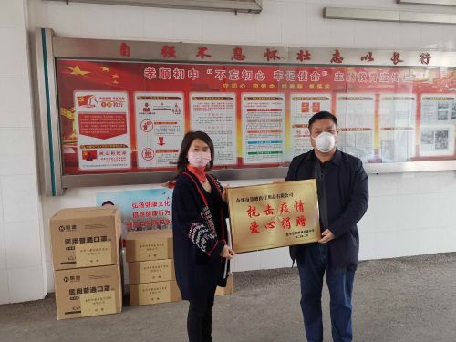 孝顺初中校长姜光彩（右）向祝兴丽赠送了“抗击疫情 爱心捐赠”牌匾