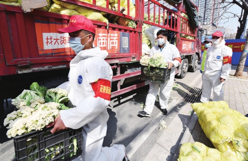  武汉市发展改革委下沉社区干部正在卸运“爱心菜”。武汉市发展改革委/供图