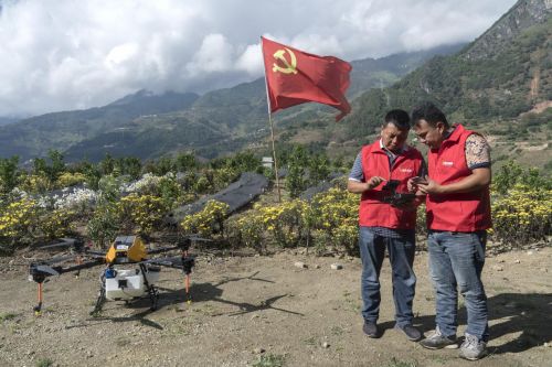 ▲老窝村党总支书记左雪锋指导村民使用无人机。（摄影：穆功）

