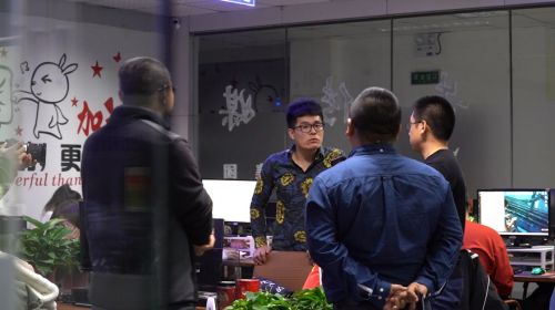 ▲在哈尔滨平房区的办公室内，张磊（右二）正在和几位主要团队成员讨论工作。（摄影 多福）

