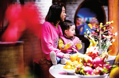  图为北京一家餐馆门口，一位女士带着孩子在等位。中国经济导报记者苗露/摄