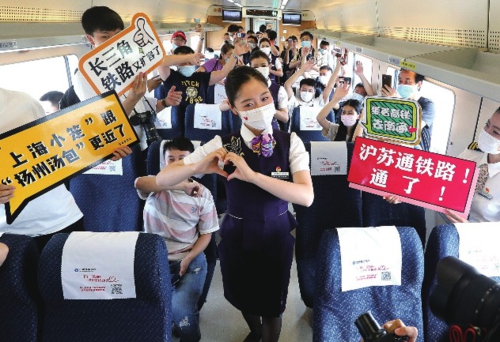  图为由上海至南通的C3836次列车乘务员在车厢内为旅客表演节目。新华社