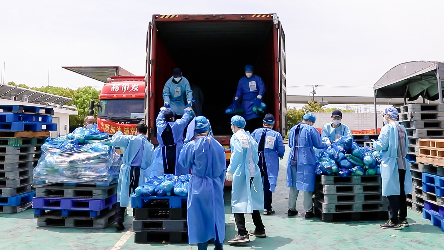 近百名上海抗疫党员突击队（浦东组）的成员用双手将大米、食用油等200多吨的各种生活物资分拣、打包、装