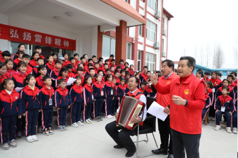 雷锋日志愿者到学校教学生学唱革命歌曲。摄影：杜昱葆