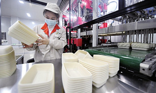  河北邯郸武安市工业园区里，工人认真整理刚生产出来的可降解餐盒。新华社