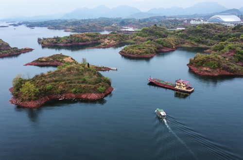  图为在淳安界首体育中心附近的千岛湖水域，党员志愿者与环卫工人一起乘船清理沿岸及水面废弃物。新华社