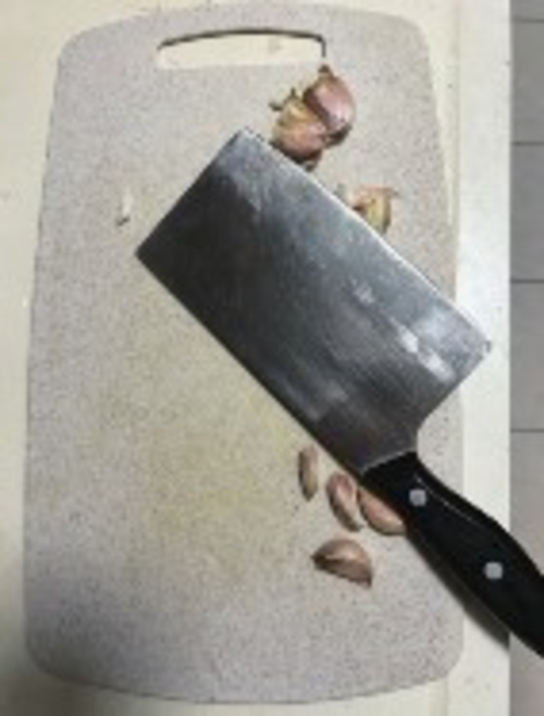  菜刀拍大蒜是百姓生活的一种常规操作。本报记者张守营/摄