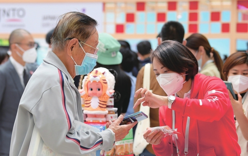  近日，以“协力同心、共创未来”为主题的中日邦交正常化50周年民间纪念活动在北京开幕。图为游客在日本企业展台前咨询。 新华社