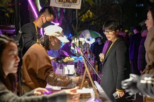 2月28日，在四川省成都市锦江区三色路夜市，市民在购买小吃。新华社记者 唐文豪 摄