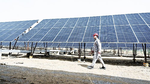  4月13日，在位于内蒙古自治区乌海市的国家能源集团乌海能源公司黄白茨光储电站，工人在巡检光伏板。新华社