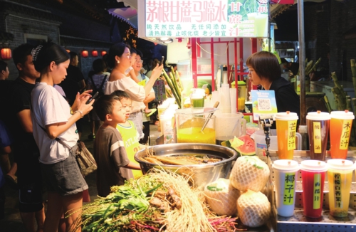  中秋国庆假期，广西南宁的夜市消费者络绎不绝，带火了当地夜经济。图为消费者在南宁三街两巷购买食品。新华社