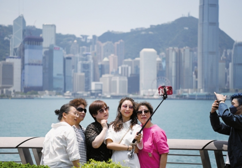 滚滚人流见证双向奔赴，深港共绘大湾区优质生活圈。图为游客在香港星光大道自拍合影。新华社