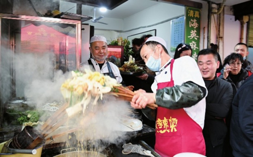  图为天水市秦州区的天水名优小吃城一麻辣烫店，商家为游客加工麻辣烫。新华社