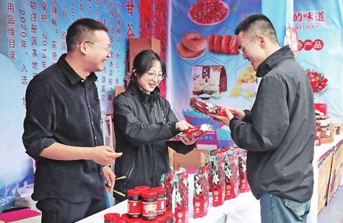  甘肃省天水市的“天水麻辣烫”火爆出圈，不仅使当地餐饮市场持续火热，还带动周边的零售、服务、文旅等消费市场同步升温。图为游客在天水市秦州区的摊位前挑选当地农特产品。新华社