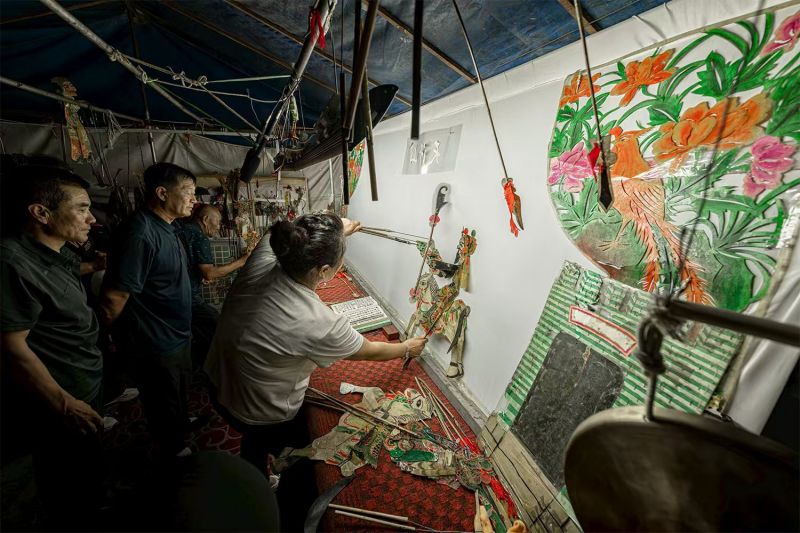 夜晚，皮影戏在凌源市通达街演出，吸引了大量市民观看。图为皮影戏后台。 刘杰 摄