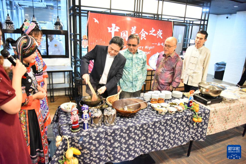 8月23日，在文莱首都斯里巴加湾市的拉克萨马纳商学院，嘉宾在“中国美食之夜——品味广西”活动上体验广西炒茶。新华社记者 李萌 摄