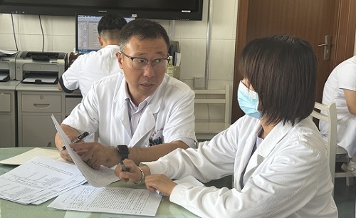 白炜（图左）在与主管医生讨论治疗方案