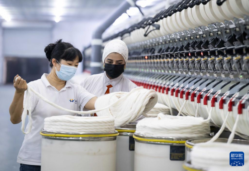 9月12日，在塔吉克斯坦哈特隆州丹加拉区的中塔合作项目丹加拉农业纺织产业园，纺纱车间主任指导一名工人工作。新华社记者 李任滋 摄