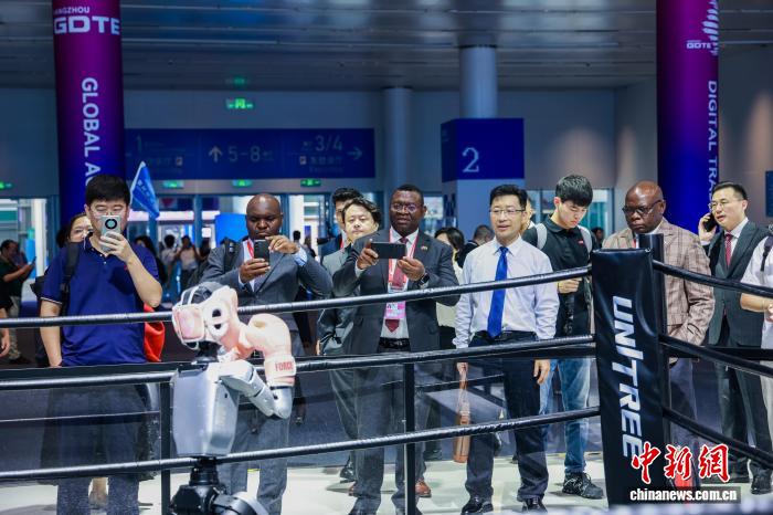 数贸会展区,国际客商观看人形机器人拳击表演。 浙江省商务厅 供图