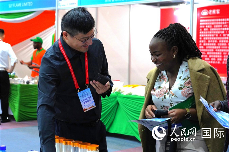 博览会现场，本地客商在与中国参展商交流。人民网记者黄炜鑫摄