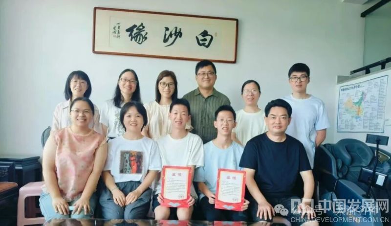 （婺城中学8位老师给孩子送喜报：左1，孩子妈妈；左2申祺泽班主任李利芬；左3左4双胞胎兄弟；左5申祺恩班主任陈峰；后排是婺城中学副书记、副校长和双胞胎兄弟的4位任课老师）